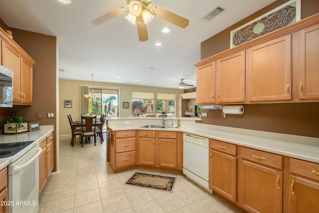 kitchen featuring sink, ceiling fan, kitchen peninsula, pendant lighting, and white appliances