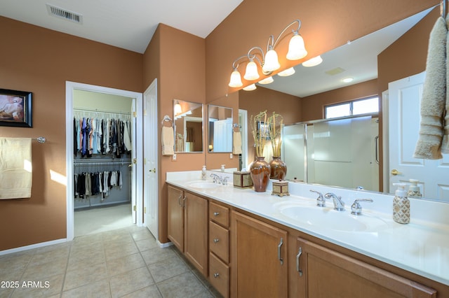 bathroom with vanity, a notable chandelier, tile patterned flooring, and a shower with shower door