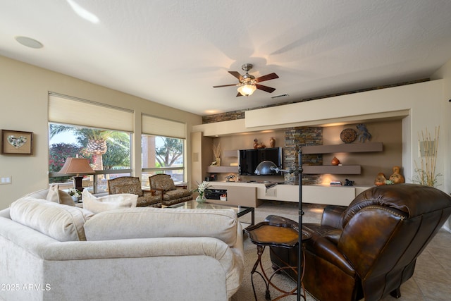 living room with a textured ceiling and ceiling fan