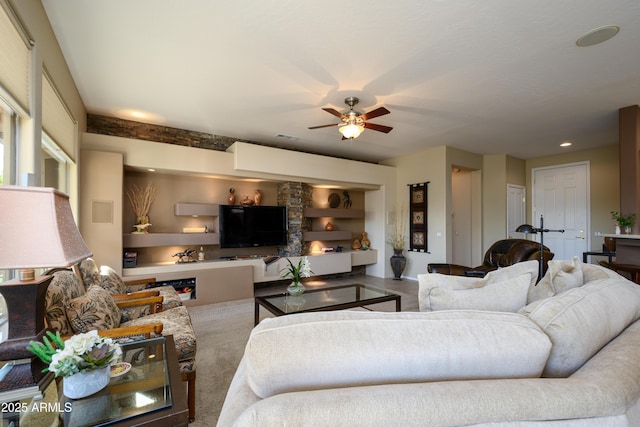 living room with built in shelves and ceiling fan