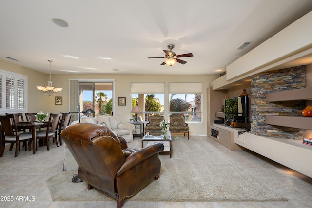 living room featuring ceiling fan with notable chandelier and plenty of natural light