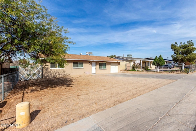 ranch-style home featuring an attached garage, fence, and concrete driveway