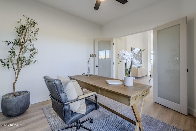 home office featuring ceiling fan, baseboards, and wood finished floors