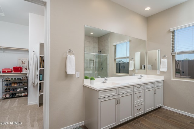 bathroom featuring a shower with door and vanity