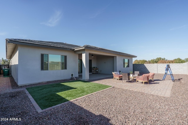 rear view of property featuring a yard, an outdoor hangout area, and a patio area