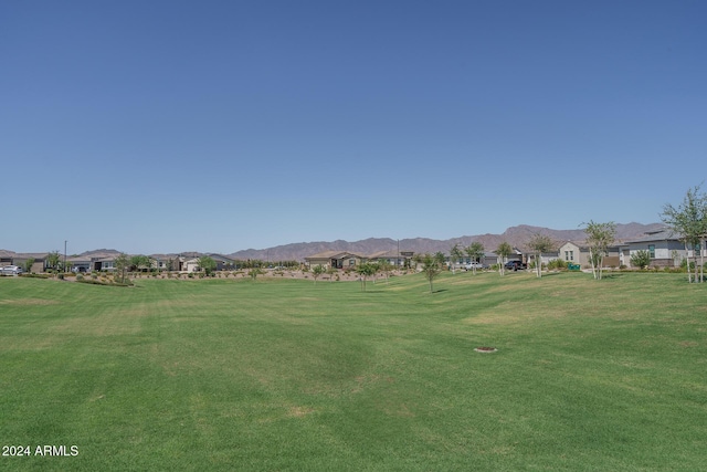 surrounding community with a mountain view and a yard