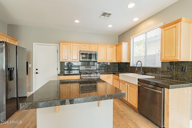 kitchen featuring sink, light wood-type flooring, tasteful backsplash, and stainless steel appliances