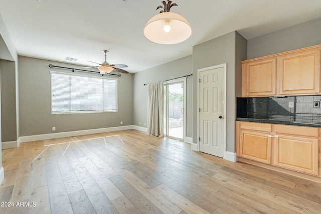 kitchen with ceiling fan, light brown cabinetry, light hardwood / wood-style floors, and backsplash