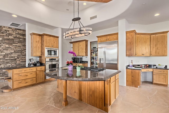 kitchen with pendant lighting, a center island, an inviting chandelier, and built in appliances