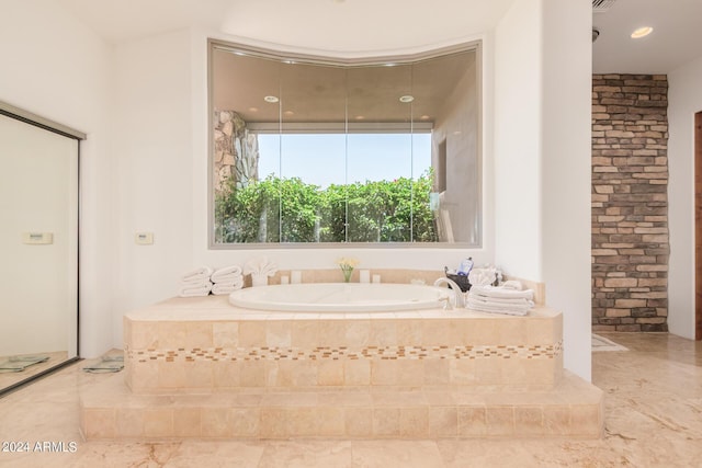 bathroom with a relaxing tiled tub