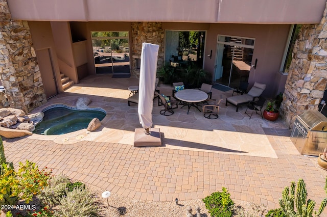 view of patio / terrace with an in ground hot tub