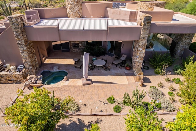 view of patio / terrace featuring a balcony and a hot tub