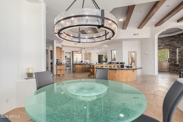 dining area featuring beam ceiling and an inviting chandelier