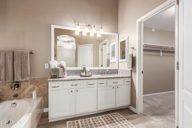 bathroom with a bath, vanity, and hardwood / wood-style floors