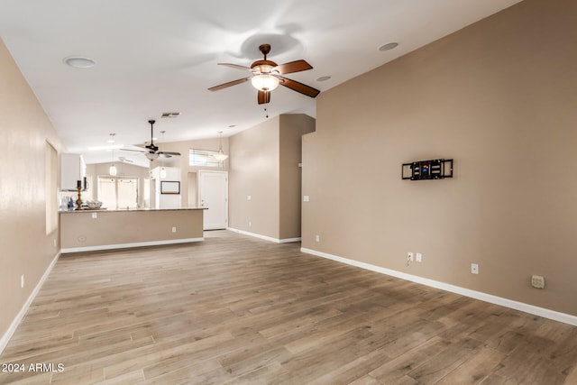 unfurnished living room featuring ceiling fan, light hardwood / wood-style floors, and vaulted ceiling