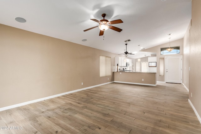 unfurnished living room with vaulted ceiling and light wood-type flooring