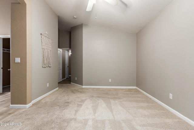 spare room featuring light carpet, ceiling fan, and lofted ceiling