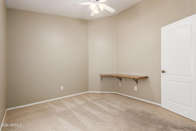 carpeted spare room with ceiling fan