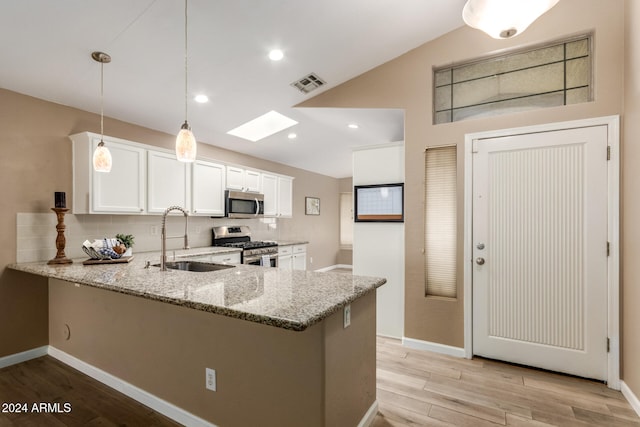 kitchen with white cabinetry, sink, stainless steel appliances, kitchen peninsula, and pendant lighting