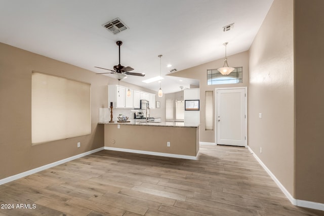 kitchen with kitchen peninsula, lofted ceiling, white cabinets, and light hardwood / wood-style floors