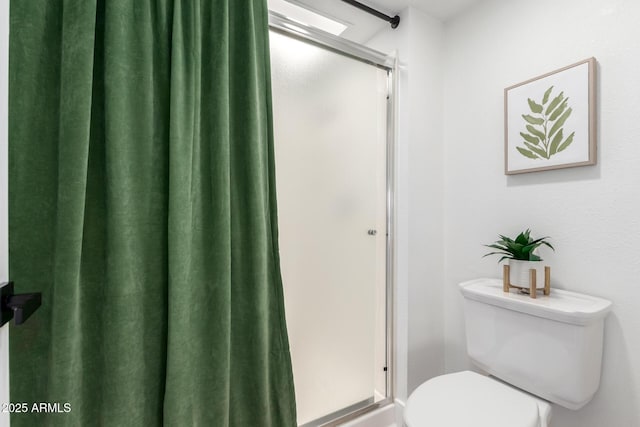 bathroom with toilet and a shower with shower door