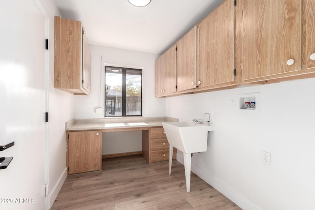 laundry room with cabinets, washer hookup, and light wood-type flooring