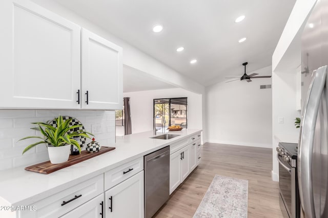 kitchen featuring decorative backsplash, white cabinets, appliances with stainless steel finishes, and sink