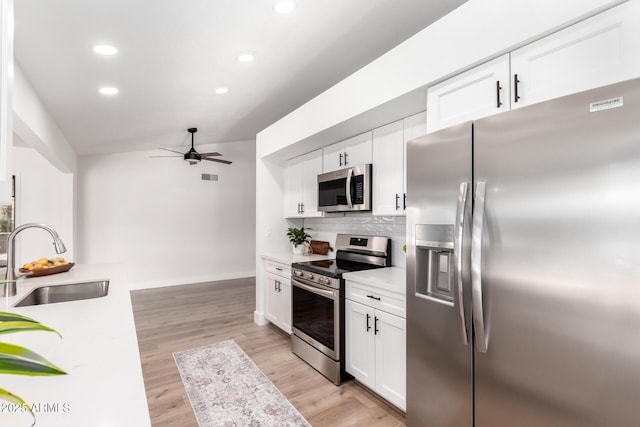 kitchen featuring appliances with stainless steel finishes, decorative backsplash, white cabinetry, and sink