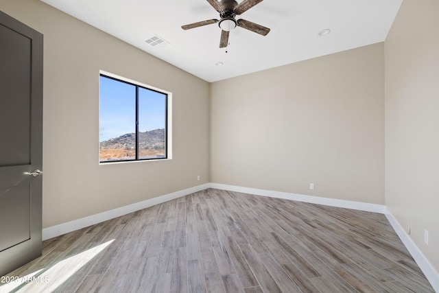 empty room with light hardwood / wood-style flooring and ceiling fan