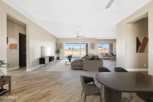 living room with light hardwood / wood-style flooring and ceiling fan