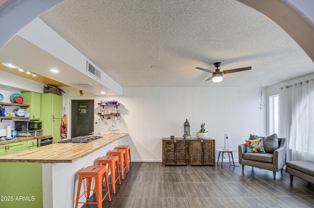 1340 E Townley Ave, Phoenix, AZ 85020 - kitchen featuring green cabinets, butcher block counters, a kitchen breakfast bar, open shelves, and appliances with stainless steel finishes