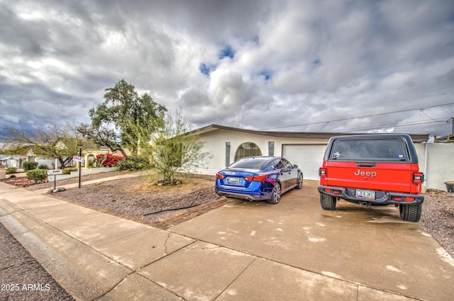 ranch-style home with concrete driveway and an attached garage