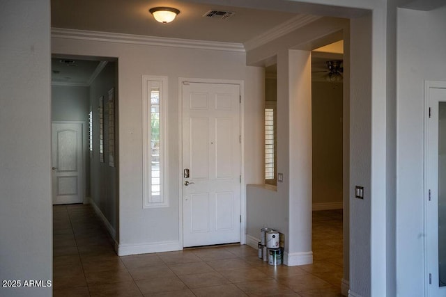 tiled foyer entrance with crown molding