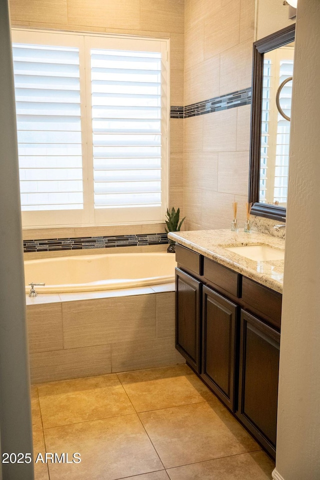 bathroom featuring tile patterned floors, tiled bath, vanity, and plenty of natural light