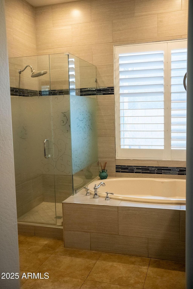 bathroom with shower with separate bathtub and tile patterned floors