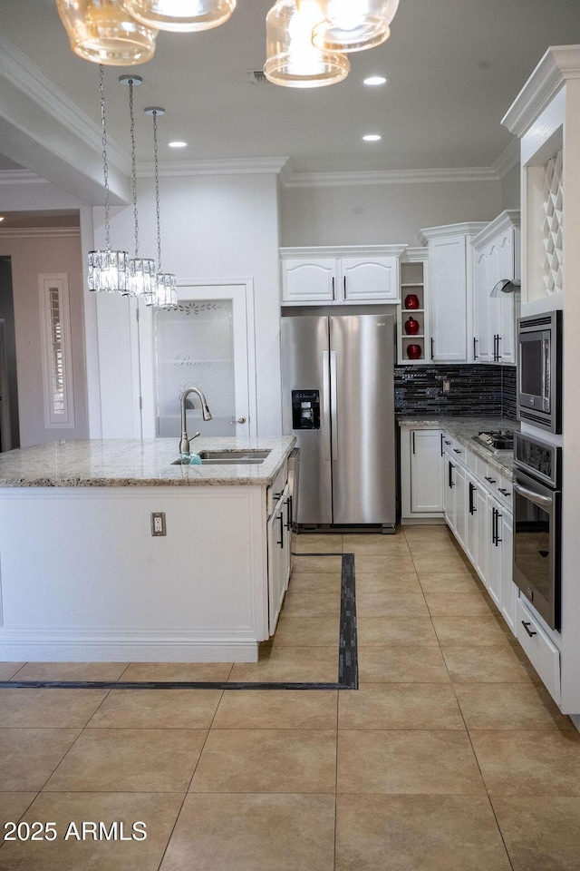 kitchen with decorative light fixtures, white cabinetry, sink, stainless steel appliances, and a center island with sink