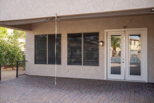 property entrance with a patio and french doors