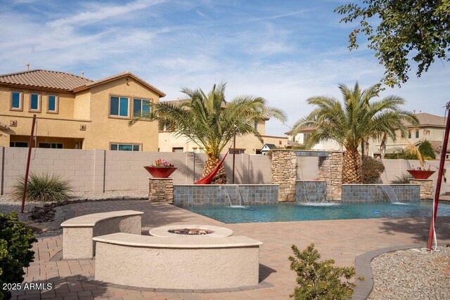 view of swimming pool featuring a patio, pool water feature, and a fire pit