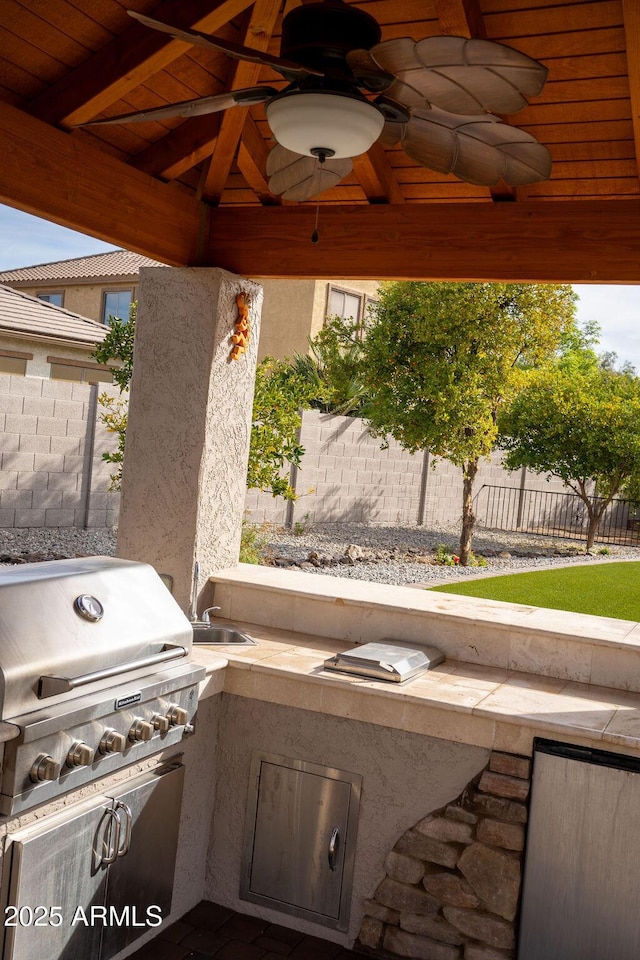 view of patio with exterior kitchen, grilling area, sink, and ceiling fan