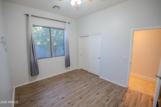 unfurnished bedroom featuring a closet, ceiling fan, and light wood-type flooring