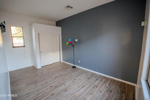 unfurnished bedroom featuring light hardwood / wood-style floors and a closet