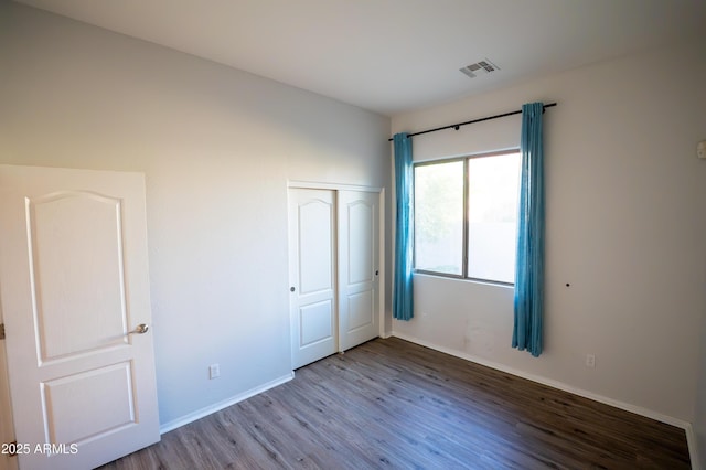 unfurnished bedroom with wood-type flooring and a closet