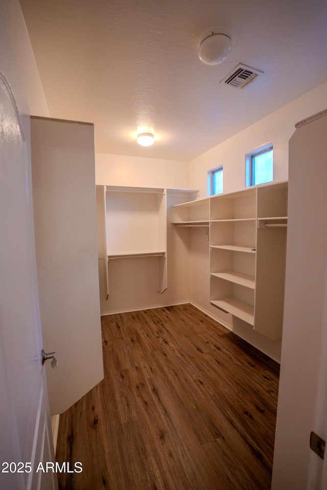 spacious closet with dark hardwood / wood-style floors