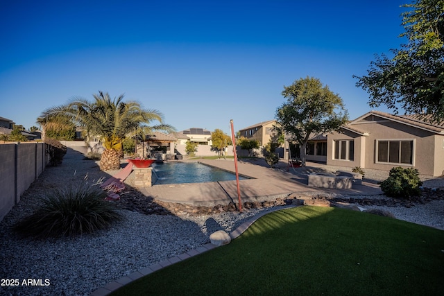 back of house featuring a fenced in pool and a patio area