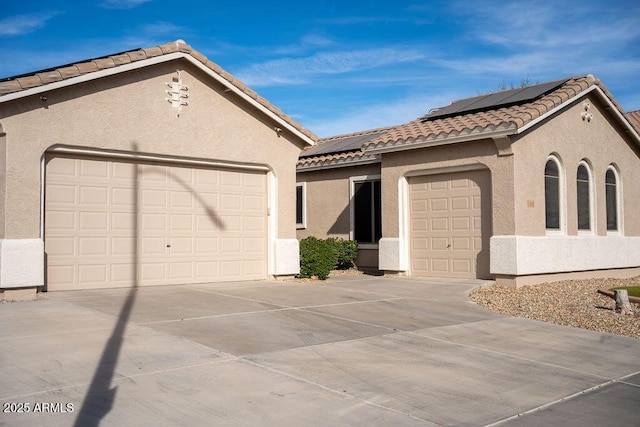 view of front facade with a garage and solar panels