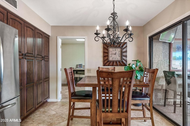 dining space featuring a chandelier, visible vents, and baseboards