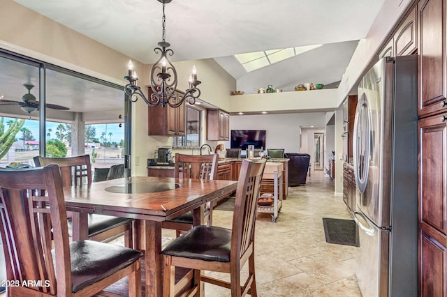 dining space featuring ceiling fan with notable chandelier and vaulted ceiling