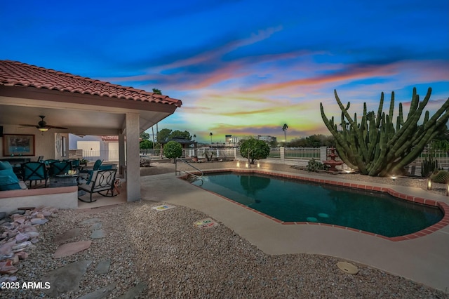 pool at dusk featuring a fenced backyard, a fenced in pool, a ceiling fan, and a patio