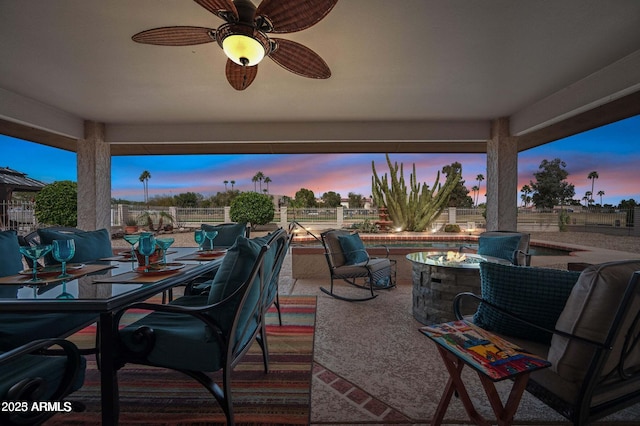 view of patio / terrace with a fire pit, outdoor dining area, and a ceiling fan