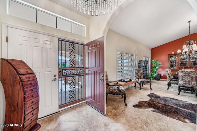 entryway with high vaulted ceiling, arched walkways, and a chandelier